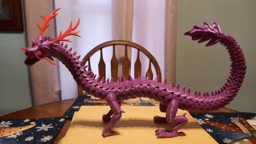 30 inch long articulated purple dragon printed in EconoFil Purple PLA, posed on a printed bridge