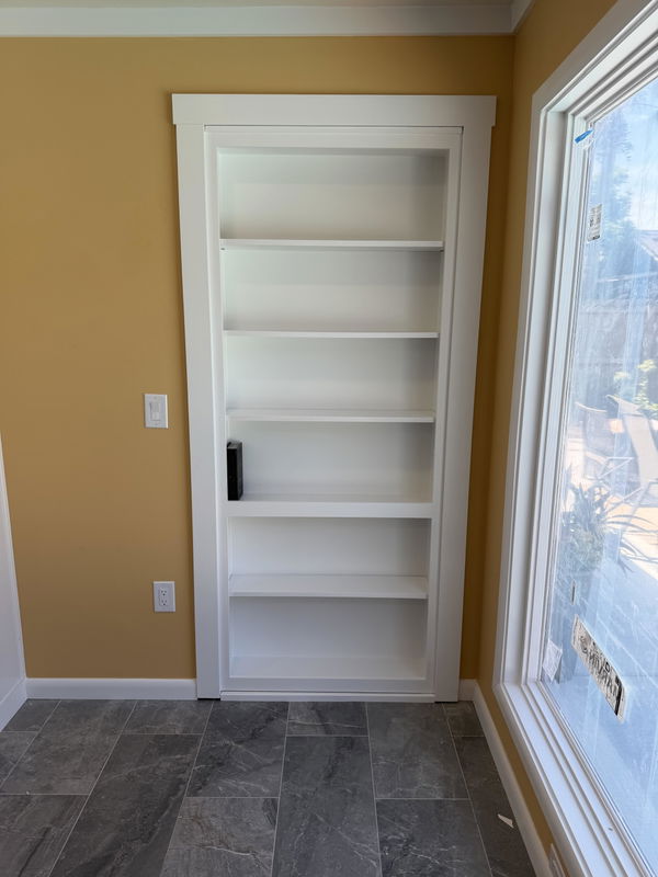 Hidden bookcase door installed in a bright room
