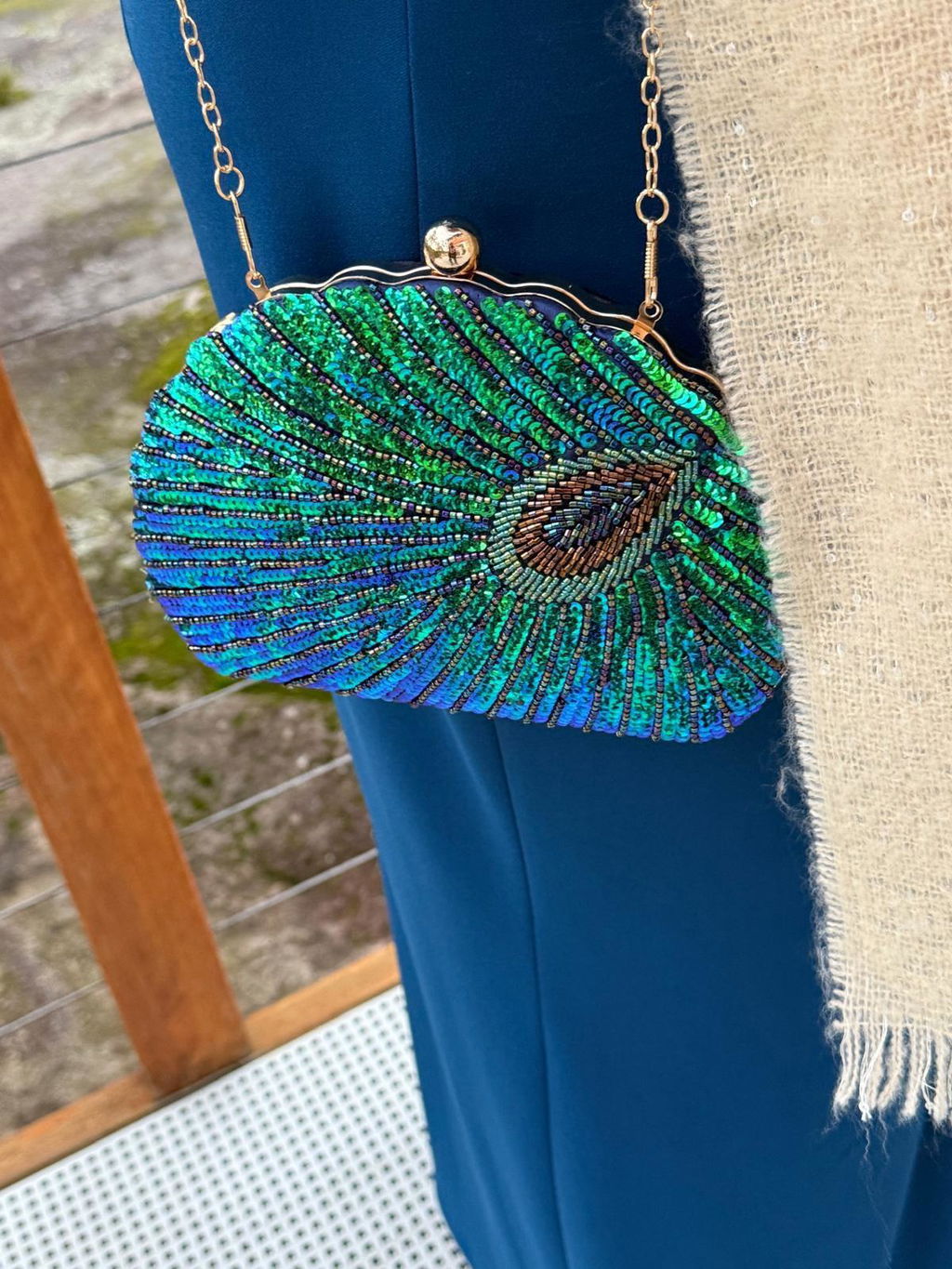 Customer wearing the Peacock Clutch with a marine blue dress