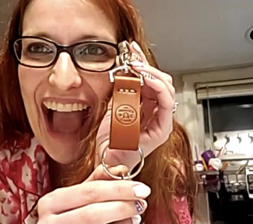 The Wander Club customer Lanae K. holding her Brown Wanderchain leather Token Holder